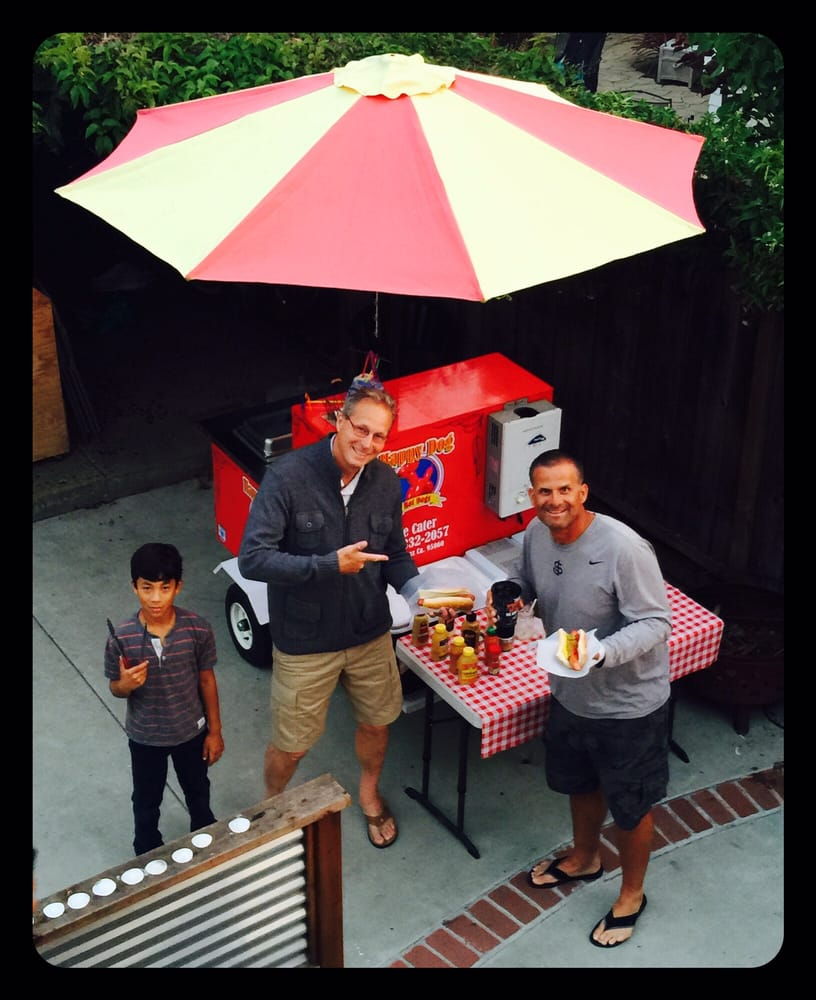 Overhead view of guests gathered around the Happy Dog Hotdogs cart at a Santa Cruz event